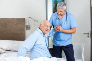 physical therapist assisting senior man
