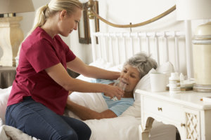 nursing aide assisting senior woman in drinking water