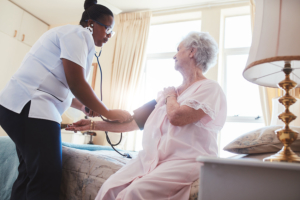 medical staff checking elderly woman's blood pressure